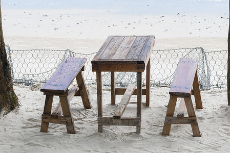 海边沙滩附近的餐馆海边沙滩上的桌子和长椅图片
