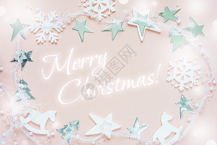 作文木制的圣诞节贺卡由白圣诞节装饰品组成雪花星圣诞树和玩具粉红色背景的摇摆马刻有欢乐圣诞节的字样贺卡网站社交媒体杂志博客艺术家等的平板布局设计图片