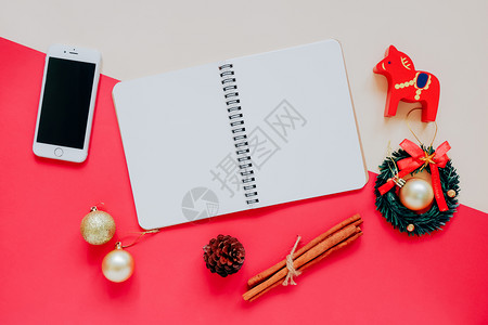 手工艺板和空白笔记本用圣诞节装饰品和智能手机制成背景丰富多彩风格微薄图片