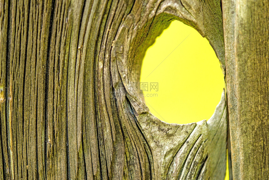 带有洞和视图为黄色背景的旧木板图片