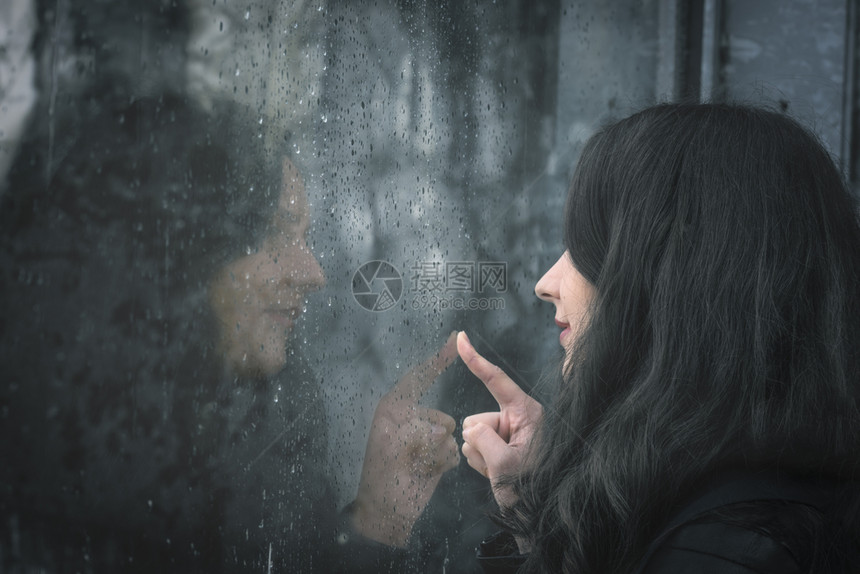 女子坐在雨窗前图片