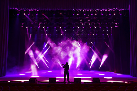 歌唱人和在明亮的表演舞台彩虹和风雾背景下图片
