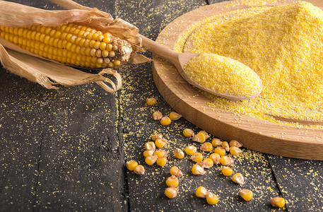 食物成分主题图象在木制桌子上用斗篷和勺子成的玉米鳕谷物和面粉背景图片