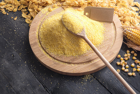 玉米面粉贴在圆木板和勺子上图片