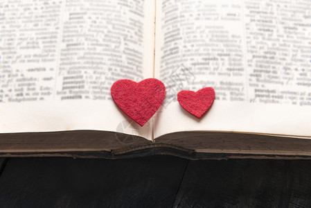 两颗红心贴在一本旧的公开书上图片