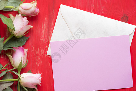 贴在封闭信上的粉红纸贺卡想法周围都是红木背景上的玫瑰一种母亲节情人和事件的概念背景图片