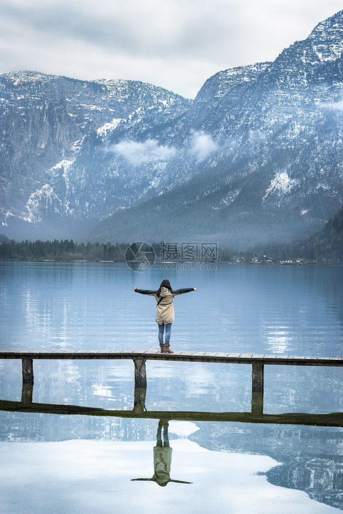 一位女站在甲板上思考并看着奥斯特里亚的阿尔卑斯山以及位于奥斯特里亚的halst图片