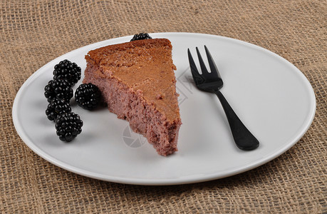 白盘上黑莓芝士蛋糕图片