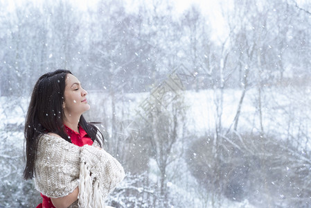 穿着红裙子披上手工制作的肩闭上眼睛享受下雪的滋味图片