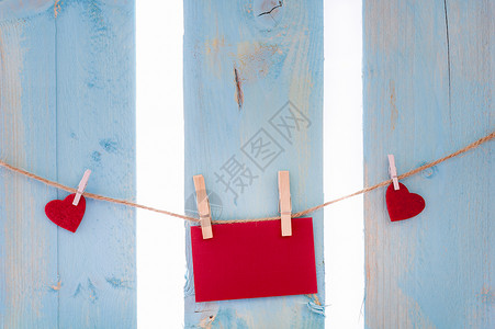 单透贴红色信卡被心包围绑在有木片的单线条上贴在蓝色栅栏上背景