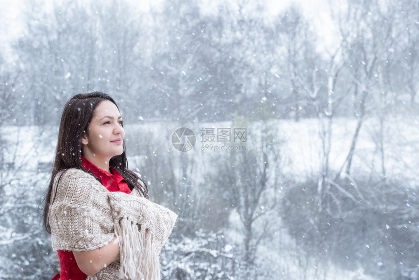 年轻美女微笑看着落下的雪花图片