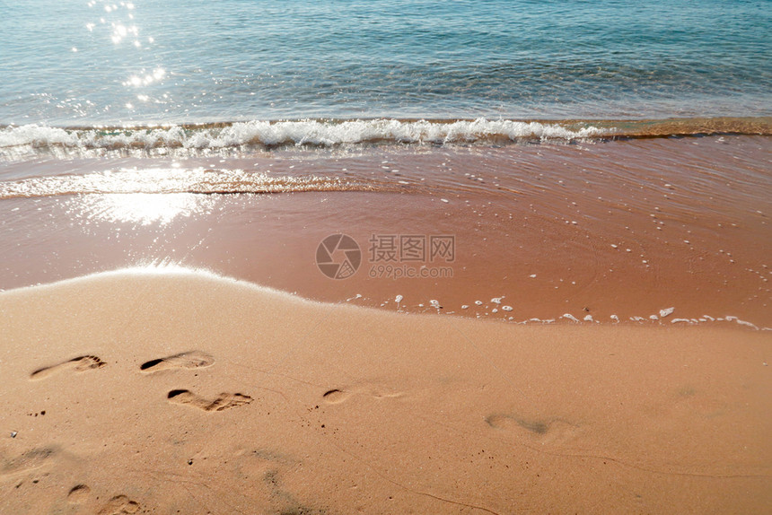 日出时沙滩上的脚印图片