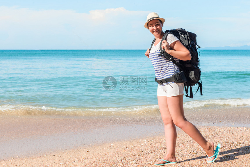 在阳光明媚的一天带着背包的游客在泰国度假胜地沙滩上行走图片