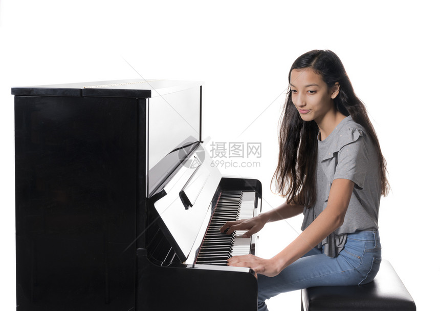 少女在弹奏直立钢琴图片