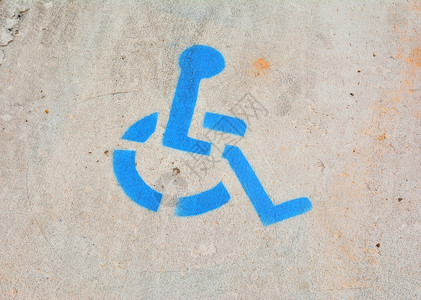 涂在沥青上的蓝色残疾人停车标志图片