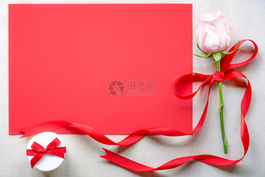 配有玫瑰和红丝带弓的玫瑰礼品盒和带有文字空间的白红色纸页放在旧布上图片