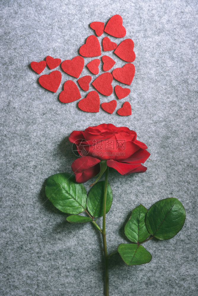 白昼的图象美丽红玫瑰和小织物心以大脏的形状展示在古老的灰色布料背景上图片