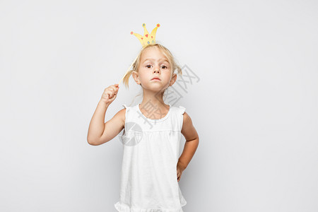 美丽的小女孩穿着纸冠身白色的后腹骨漂亮小女孩穿着纸冠身白色背景的家庭图片