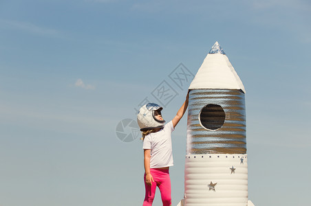身着宇航员装的快乐孩子身着手制火箭背景图片