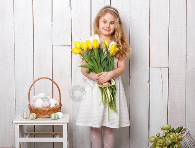 美丽的金发小姑娘手捧郁金香花束图片