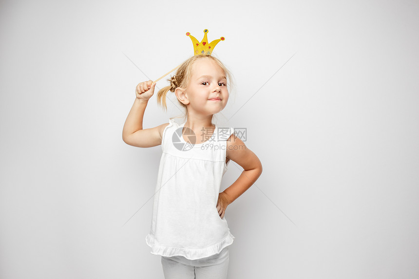 漂亮的小女孩穿着纸冠身白背景在家里穿白色背景身角图片