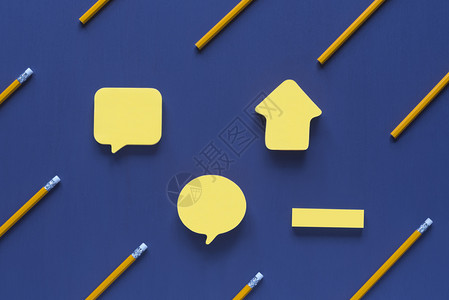 黄纸条大小和形状不同有文字位置放在蓝色木质背景上周围是黄木铅笔图片