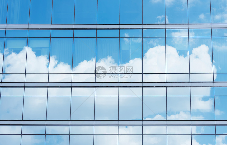 办公室大楼的紧闭反映出蓝色的天空和云彩商业背景图片