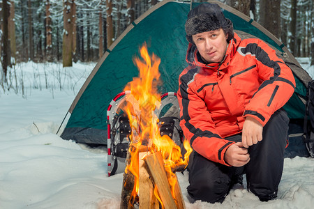 冬季森林帐篷营地火附近的活跃旅游者图片