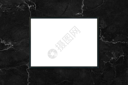 在室内黑大理石墙背景上挂着的模拟空白海报图片框可用作装配产品显示和设计关键视觉布局的模型背景图片