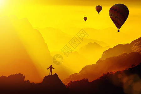 热气球山顶年轻旅行者站在山顶幻想的日落与热气球旅行的生活方式成功概念冒险在户外积极度假幸福的自由情绪背景