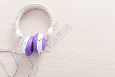 木桌上有紫色和白耳机可自由背景空间音乐放松概念高清图片