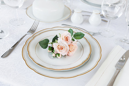 漂亮的装饰桌上面有白色板眼镜餐具和豪华桌布上的鲜花图片