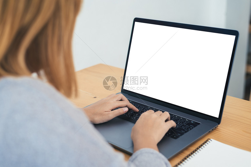 在家办公室工作时使用笔记本电脑并空白屏幕打字在家通过便携式计算机工作的商业妇女在家享受时间图片