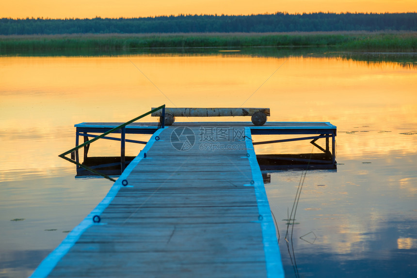 黎明时在平静湖附近的原木头码图片