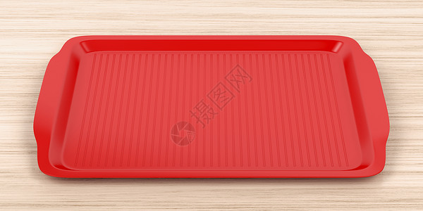 木制表格上的空红色塑料托盘图片