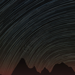 恒星足迹和远处的岩石抽象背景夜晚天空中有恒星足迹岩石的轮廓图片