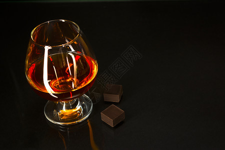 斯奈夫特黑底的白兰地玻璃和巧克力白兰地玻璃威士忌白兰地法郎玻璃和黑底的巧克力背景