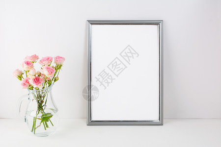 带有粉红色玫瑰的银框架模型肖像或海报白框架模型用于展示艺术作品的空白框架模型银色框架模型带有粉红色玫瑰背景图片