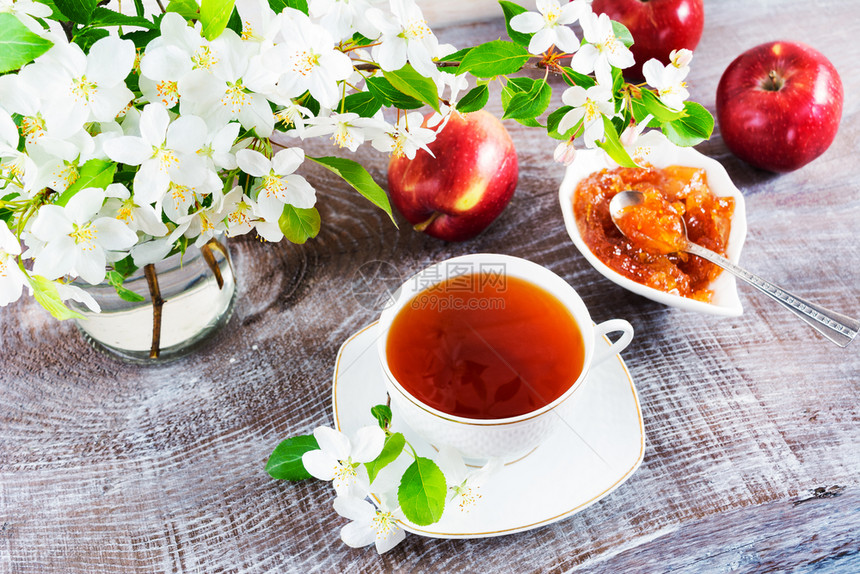 茶杯早餐配有鲜花茶杯放在木桌和苹果酱上图片