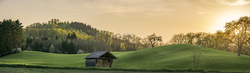 日落全景和德国的绿山日落全景绿山和金色天空下的森林靠近西南德国的城市Schwabisch大厅图片