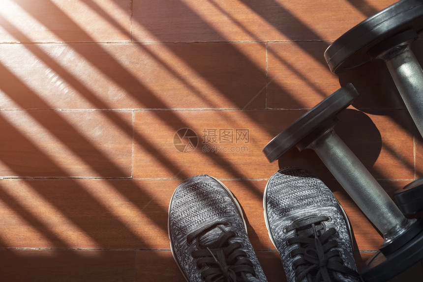 健身运动和锻炼概念木制地板机智的哑铃木制地板有窗户光和影子的哑铃复制空间的哑铃添加文字信息的照片设计艺术工作的背景图片