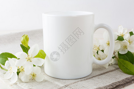 白咖啡杯装苹果花白咖啡杯装苹果树枝开花空杯装作设计宣传图片