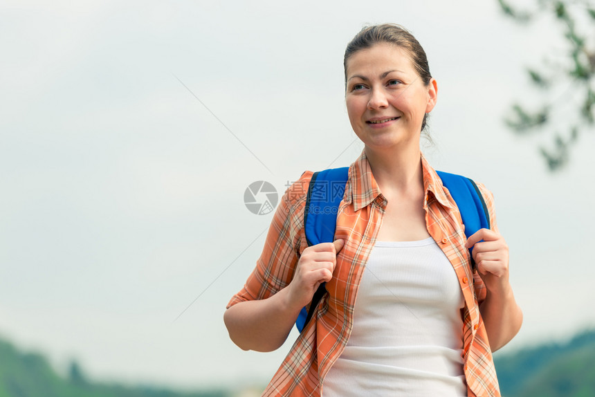 带着背包的棕发黑女人在远足中背着自然的图片