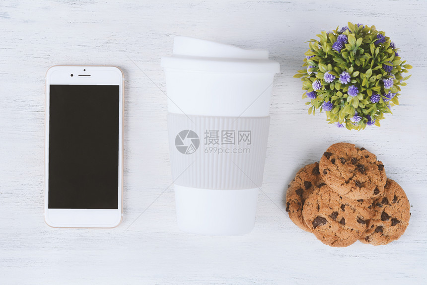 空屏幕上方带有塑料咖啡杯的袖子和饼干放在白木背景上空屏幕带有塑料咖啡杯和饼干图片