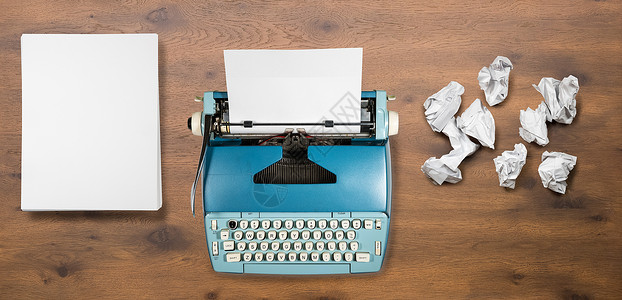 许多尝试失败的小说旧电动打字机现代电动打字机在木制桌边背景上有文件准备写新书或小说台式桌面上有许多页失败旧电动打字机有许多尝试失背景