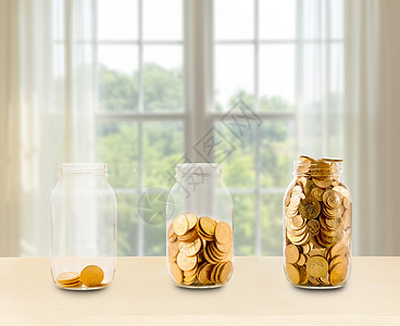 投资或退休储蓄概念三个玻璃罐在明窗前装满金币的玻璃罐子图片