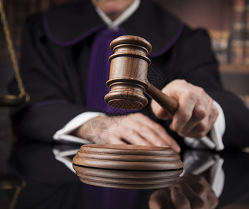 正义与法律观念法庭上的男法官法官在法庭上敲木槌的男法官图片