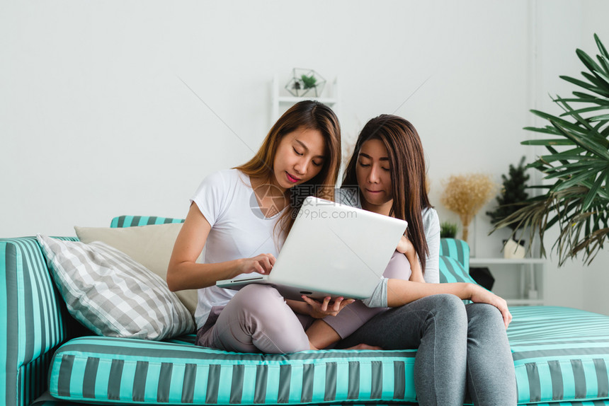 姐妹俩坐在沙发上看着笔记本图片