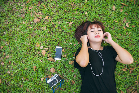 女士躺在草地上听音乐图片