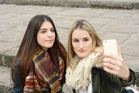 两位年轻女友一起旅行时带着智能手机自拍的肖像旅游概念户外图片